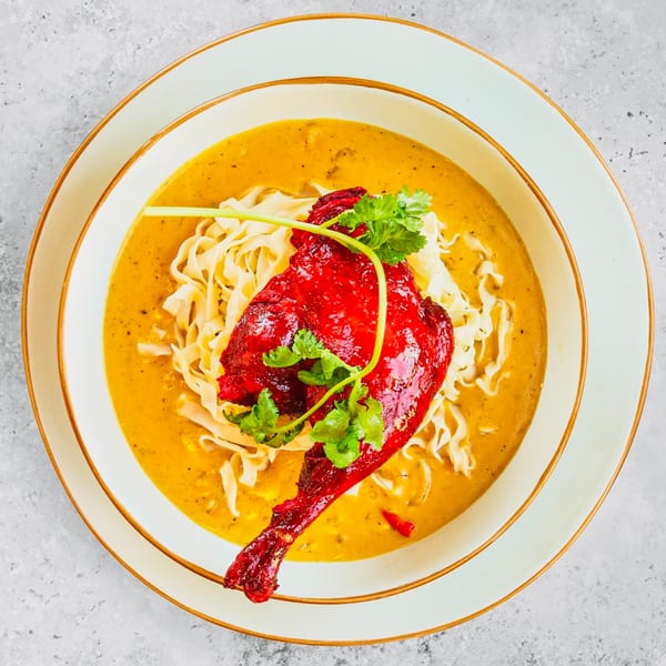 Pattaya Kitchen's red curry duck with noodles and cilantro in a yellow bowl.
